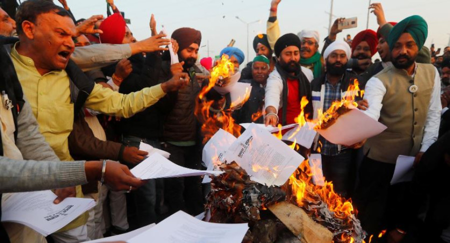 Indian farmers burn legislation in show of defiance