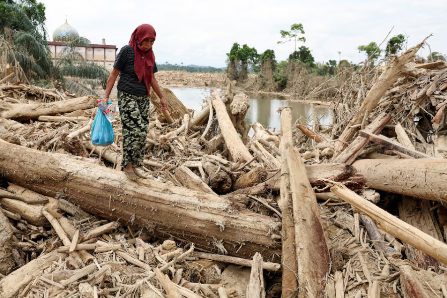 Indonesians climb over logs in walk to aid centre as flood deaths exceed 900