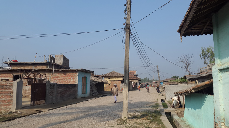 Electricity poles stand in the middle of the road in Sarlahi