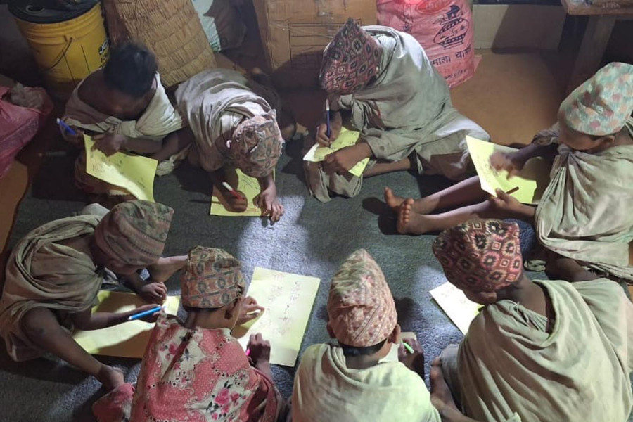 Raute children learning alphabets, without letting the chieftain know